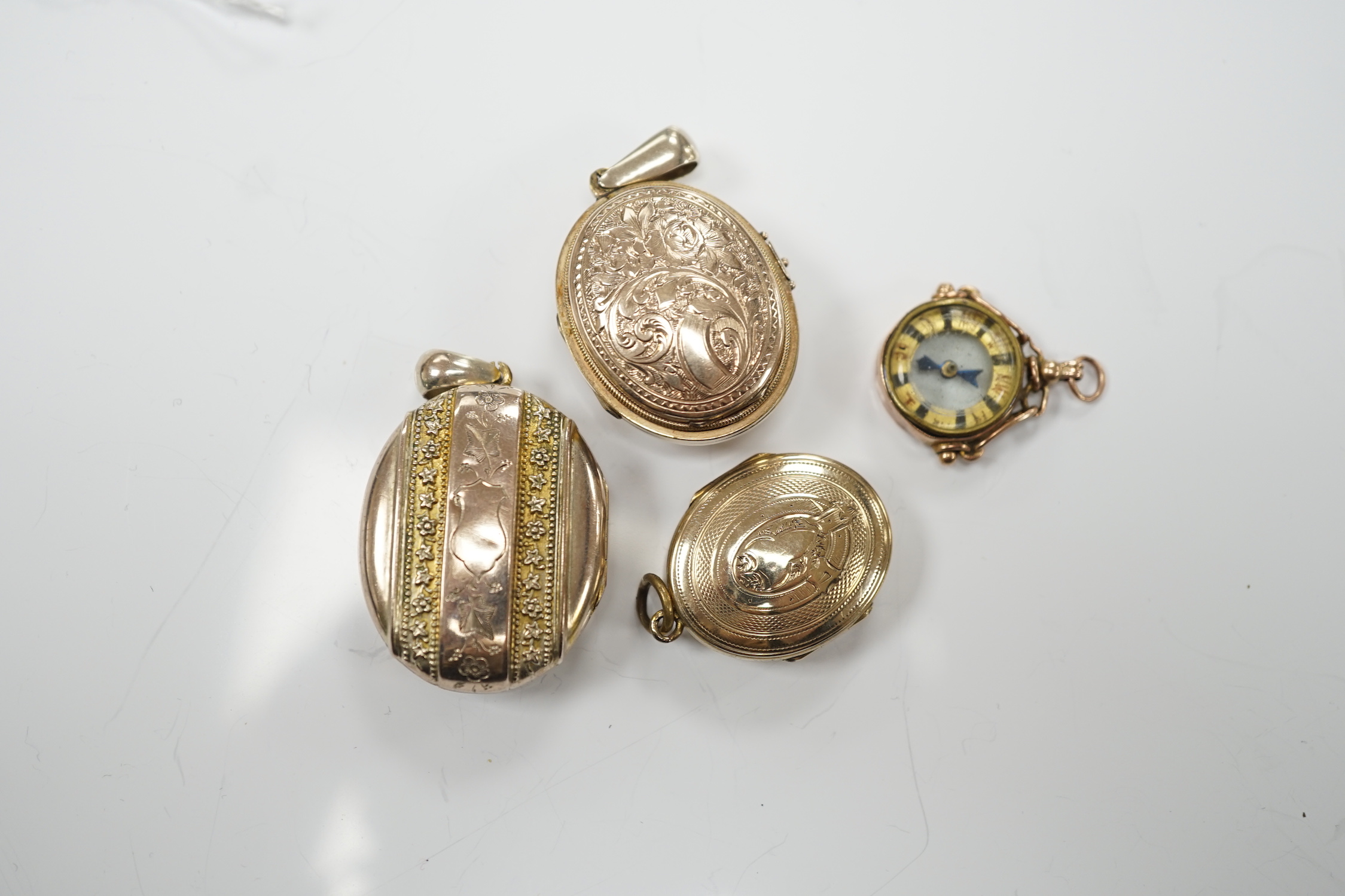 Three assorted early 20th century and later engraved yellow metal overlaid oval lockets including turquoise set, largest 33mm and a 9ct gold mounted compass charm.